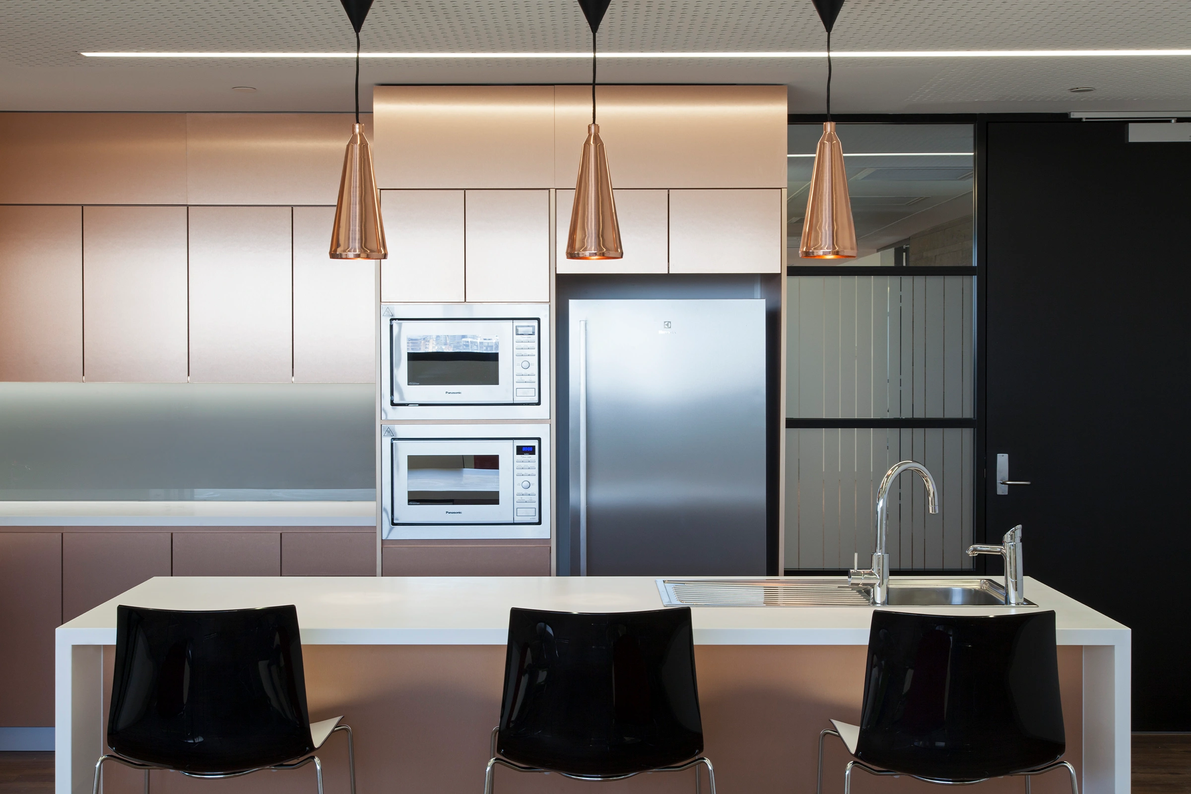 UTS Building 1 Levels 20–21 workplace kitchen with copper-toned cabinetry and pendant lights