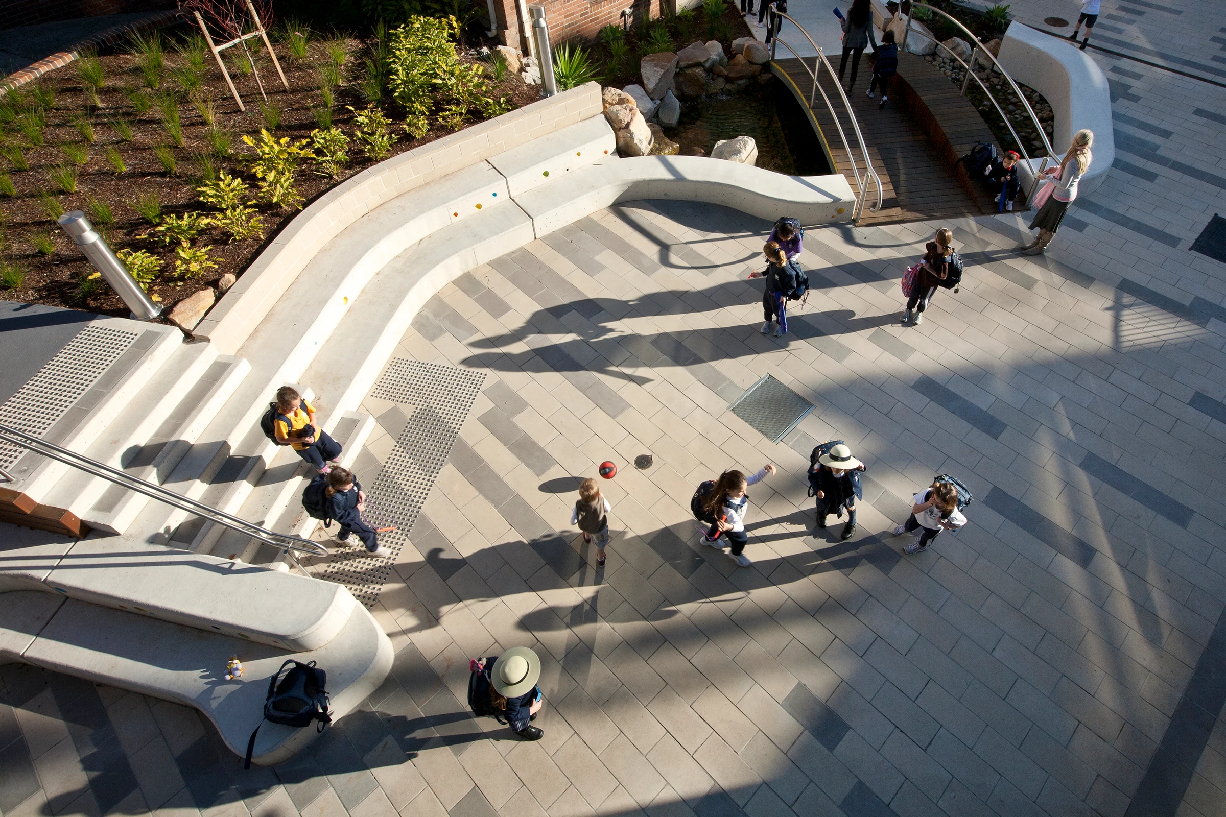 Wenona Woodstock Junior School aerial view of children playing in the outdoor learning area with curved amphitheatre seating