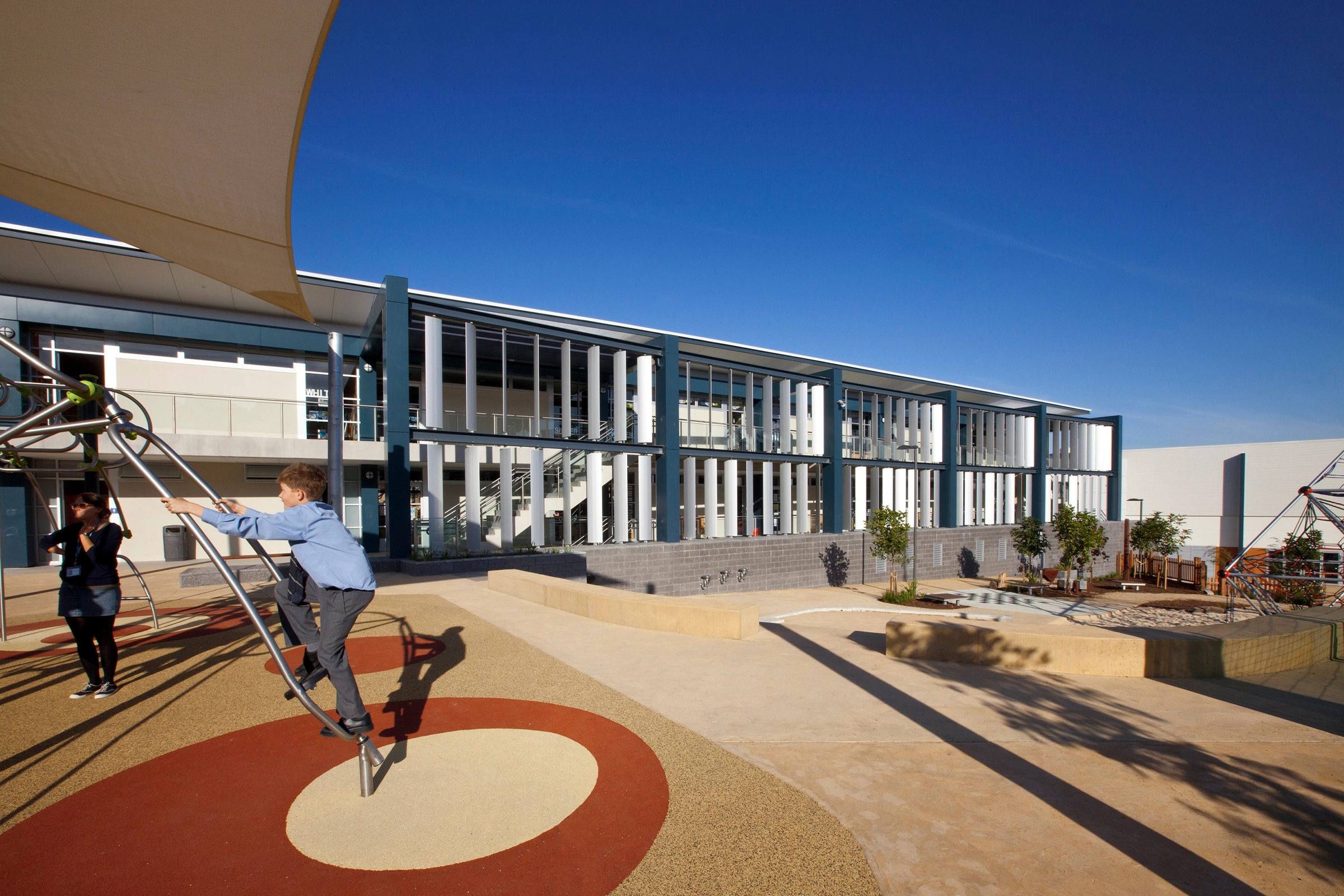 Children playing in the architecturally designed teaching and learning building school playground, at Redlands Junior School